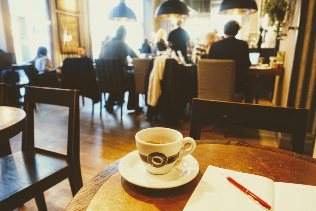 カフェのテーブルに置いたコーヒーとノートとペン