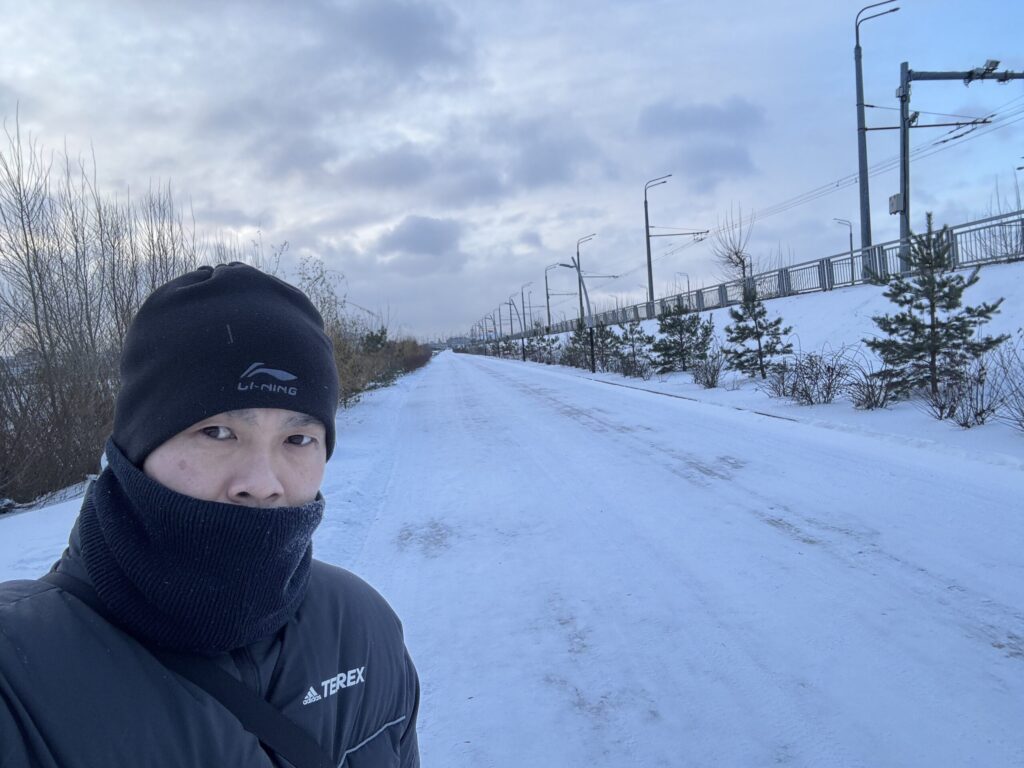 防寒着を着て雪に覆われたロシア・カザンの道を歩く筆者